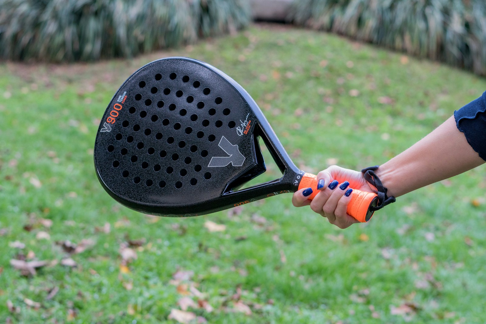 Close-up of a player gripping a padel racquet outdoors