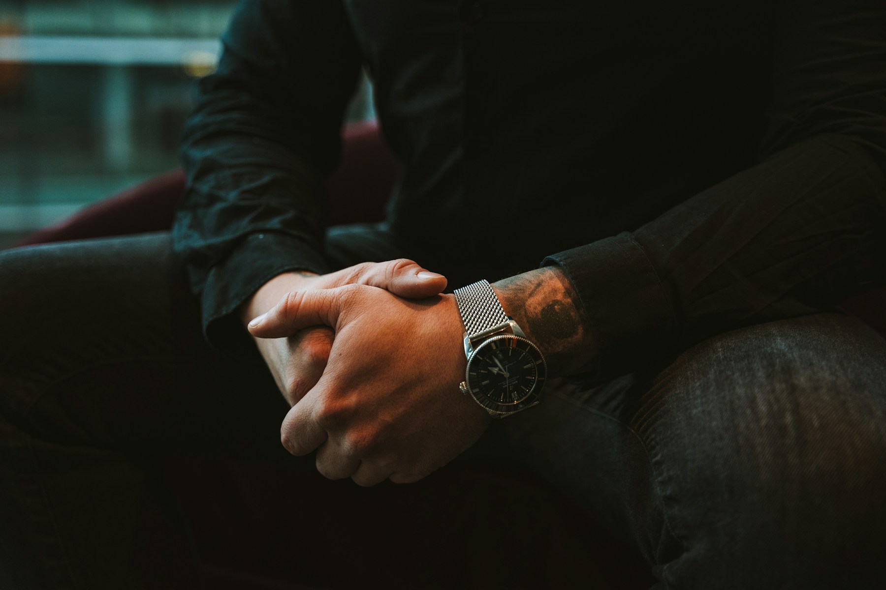 Close-up of relaxed, clasped hands resting in a person's lap